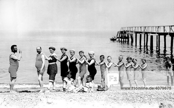 Historische Aufnahme  Menschen der Größe nach aufgereiht  Orgelpfeifen  am Strand  ca. 1920