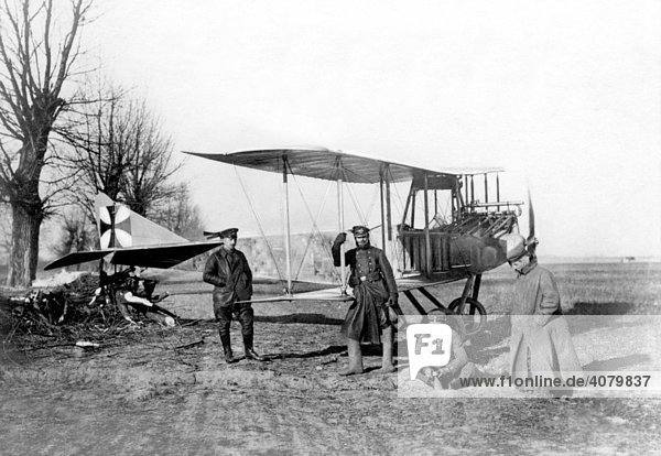 Historische Aufnahme  Erster Weltkrieg  Luftwaffe  Deutsches Flugzeug in der polnischen Tiefebene an einem Baumstumpf verankert. Die beiden Flieger führen Bomben.
