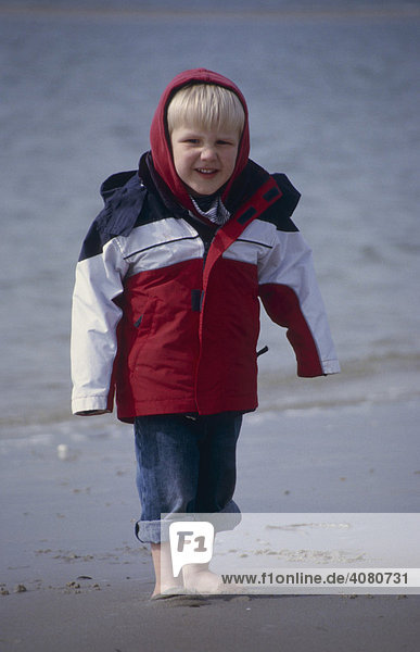 Three-year-old boy standing on a beach