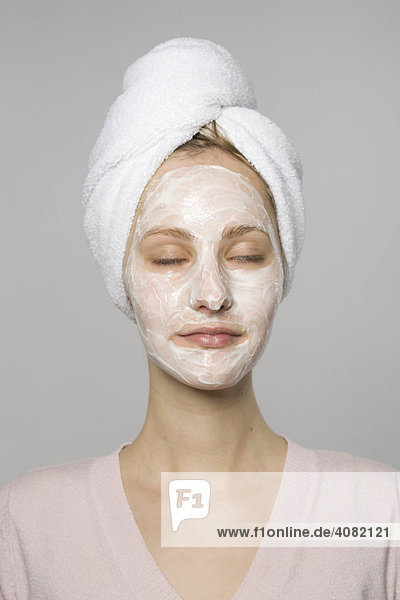 Young woman with face mask and white towel