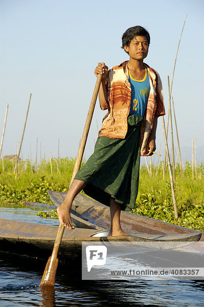 Young man rows with his leg Inle Lake Shan State Burma