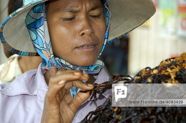 Woman sells fried spiders spider town Skun Cambodia