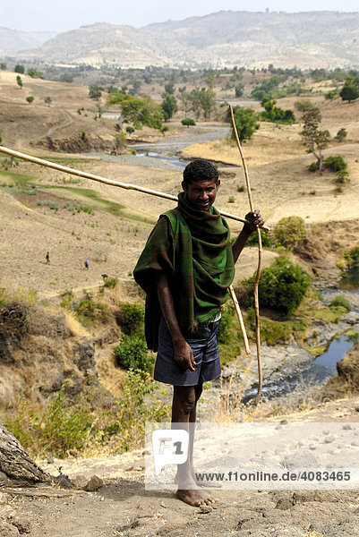 Shepherd stands barefoot in arid landscape near Bahir Dar Ethiopia