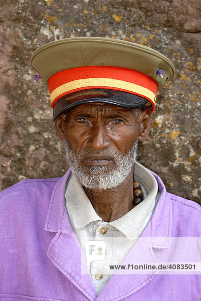 Security guard in Haile Selassie look with cap in front of the rock hewn church Beta Maryam Lalibela Ethiopia
