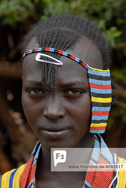 Portrait junges hübsches Mädchen mit buntem Kopfschmuck auf dem Markt von Keyafer Äthiopien