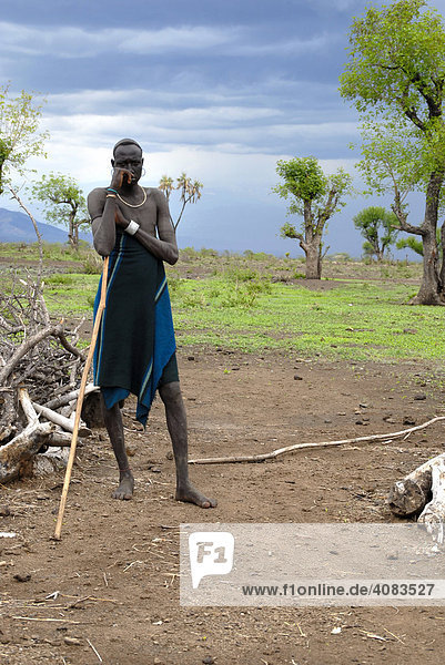 Man of the Mursi people leans against his stick Ethiopia