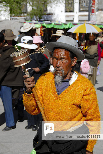 Tibetan man with prayer wheel in his hand Jokhang Kora Lhasa Tibet China