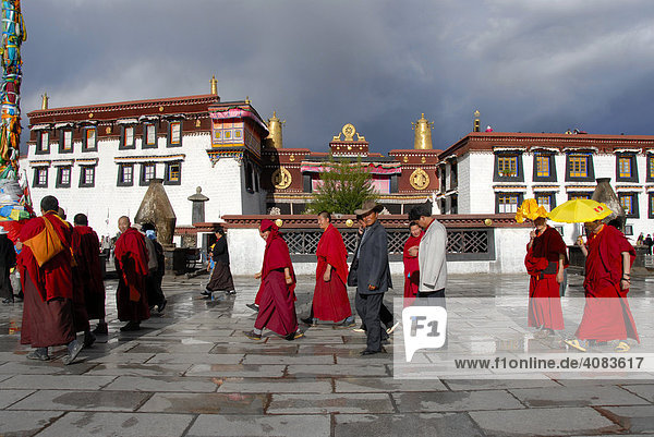 Tibetan pilgrims and monks at the Kora at the main entrance of the Jokhang Temple Lhasa Tibet China