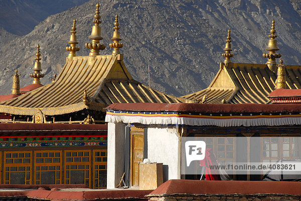 Buddhist monk on the golden roofs of Jokhang Temple Lhasa Tibet China