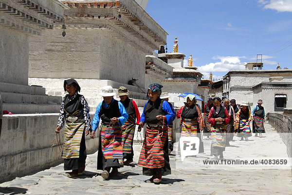 Tibetan pilgrims in colourful traditional dress at kora in Tashilhunpo Monastery ShigatseTibet China