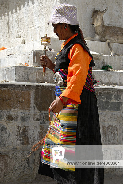 Tibetische Pilgerin in Tracht mit Gebetsmühle in der Hand Tashilhunpo Kloster Shigatse Tibet China
