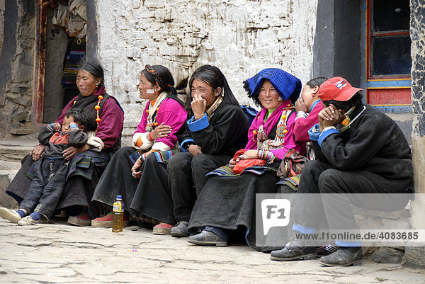 Tibetische Pilgerinnen in Tracht sitzen nebeneinander im Kloster Rongbuk Tibet China