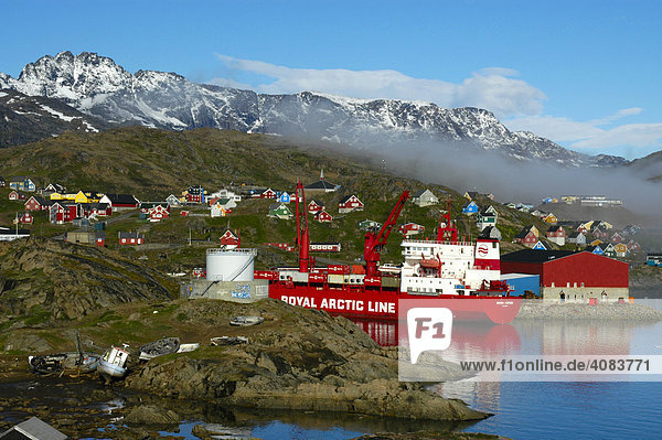 Versorgungsschiff der Royal Arctic Line im Hafen der Stadt mit bunten Häusern Ammassalik Ostgrönland