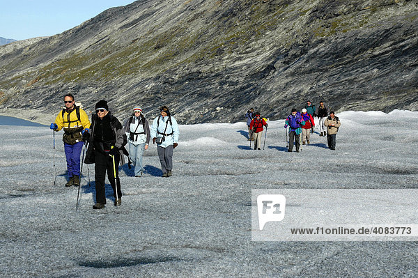 Hikers walk on inland glacier Apuserserpia at Nagtivit Eastgreenland