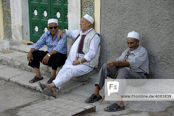 Drei Gläubige sitzen vor Gurgi Moschee Medina Tripolis Libyen
