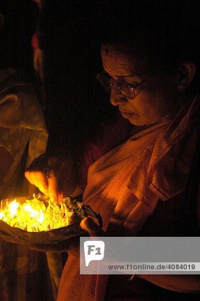 Frau hält brennende Butterlampen in der Hand Kathmandu Nepal