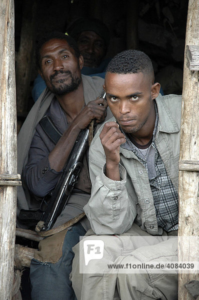 Two men with a rifle in a hut Ethiopia