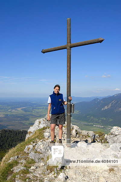 Bergsteigerin am Gipfelkreuz auf dem Berggipfel Ettaler Manndl (1633 m) Laberberg Bayern Deutschland