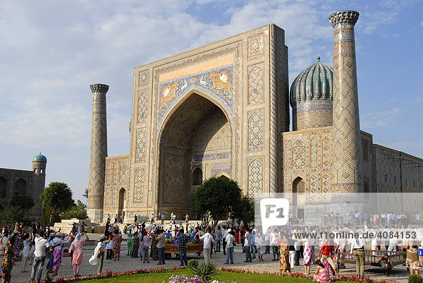 Menschen tanzen vor Medrese Sher-Dor Registan Samarkand Usbekistan