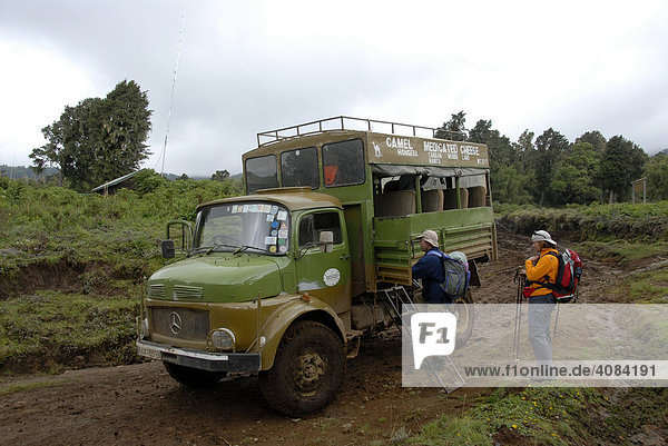 Old Mercedes lorry converted to a safari lorry on muddy dirt road Mount Kenya National Park Kenya