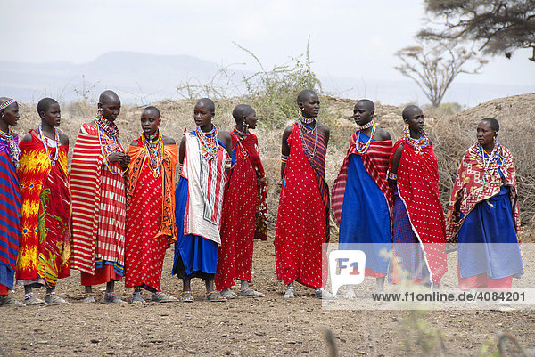 Masai woman dressed in colourful capes stand side by side Amboseli National Park Kenya