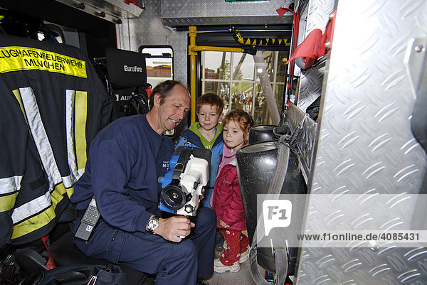 A Fireman explains a heat searching instrument to children