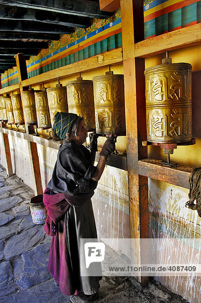 Tibeterin reinigt Gebetsmühlen  Trundruk Tempel nahe Lhasa  Tibet  Asien