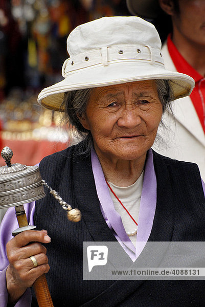 Alte Frau mit Gebetsmühle auf dem Barkor (Rundgang um den Jokhang Tempel) Lhasa  Tibet