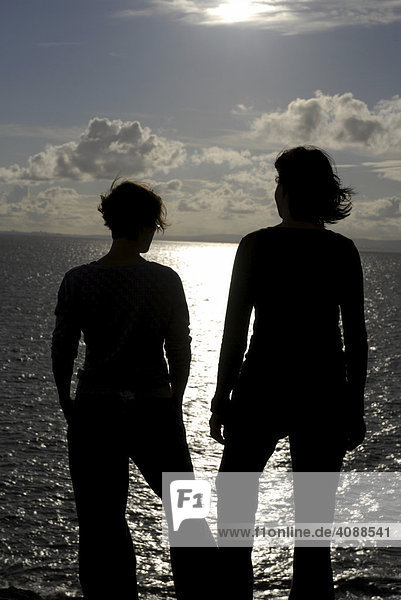 Silhouetten von zwei Frauen  Blick auf das Meer  England  Großbritannien