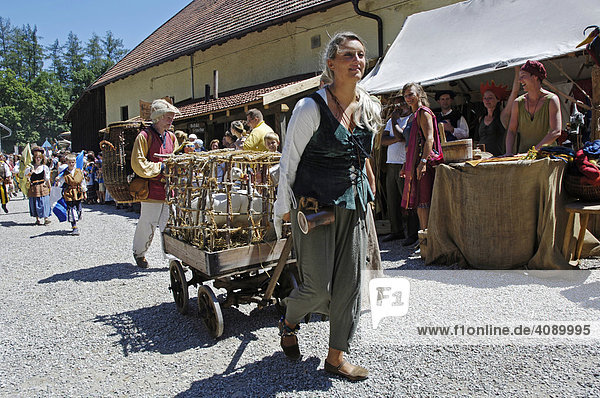 Woman in mediaeval medieval costume at move trails hay wagon with geese  knight festival Kaltenberger Ritterspiele  Kaltenberg  Upper Bavaria  Germany