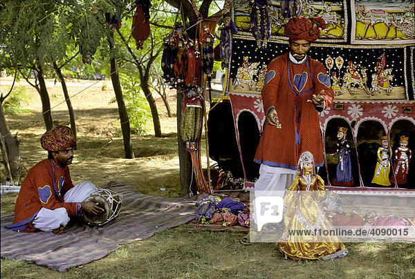 Puppenspieler mit Fadenkreuz im Mund lässt eine Tänzerin tanzen  Pushkar Fest  Pushkar  Rajasthan  Indien