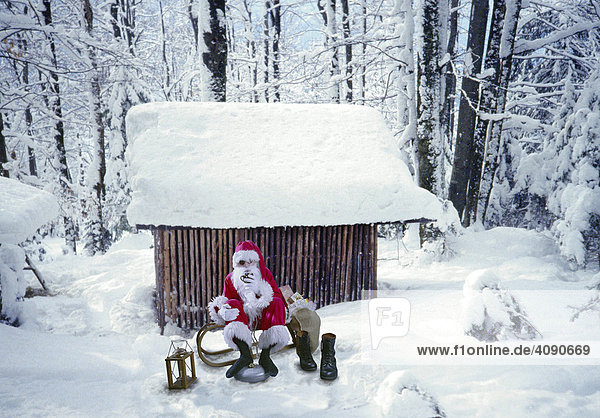 Weihnachtsmann vor verschneiter Hütte  Pause