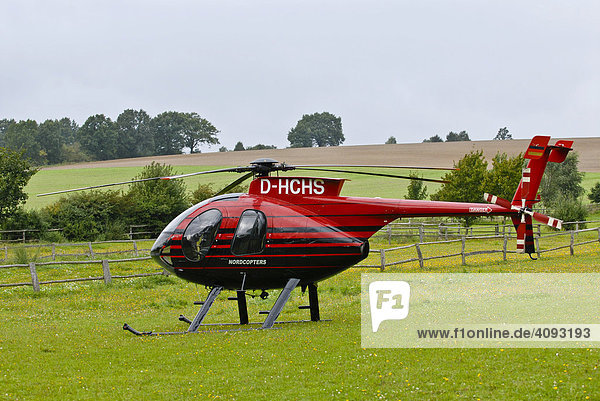 Helikopter MD500E wartet startfertig für Rundflüge auf einer Wiese in Eitzen  Niedersachsen  Deutschland