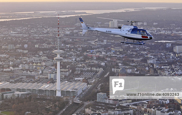 Eurocopter AS 350 im Flug mit Blick auf den hamburger Fernsehturm  Heinrich-Hertz-Turm und das Messegebäude  Hamburg  Deutschland