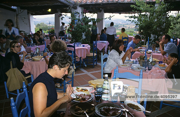 Woman enjoys a dinner in the restaurant Su Gologone Sardegna Italy