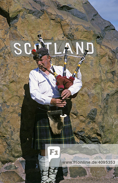 Dudelsackspieler vor Grenzstein an schottischer Grenze in Carter Bar Schottland Großbritannien