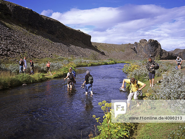 A group of hikers are fording a stream  Joekulsarglufur National Park  Iceland