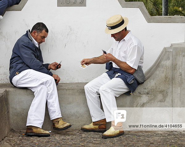 The drivers for the basket sledges playing cards and wearing a typical outfit  Monte  Madeira  Portugal