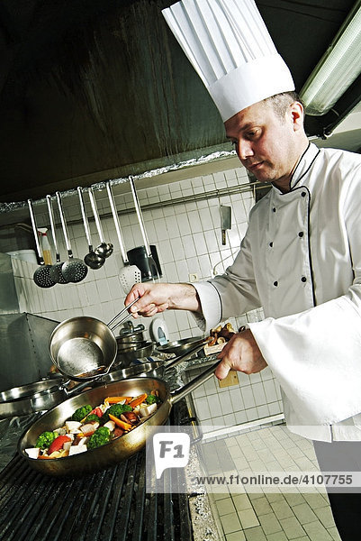 Chef preparing a meal in a restaurant kitchen