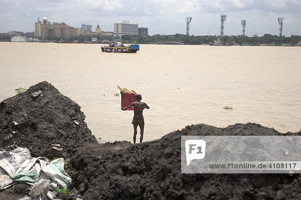 Man shortly after his bath  Kolkata  Calcutta's skyline at back  Howrah  Hooghly  West Bengal  India
