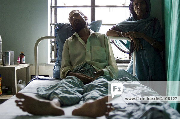 Anwari Mondol  35  lebensgefährlich an Tuberkulose erkrankt  er liegt auf Kosten einer Hilfsorganisation im Privatkrankenhaus Shree Jain  neben ihm seine Mutter  Howrah  Hooghly  Westbengalen  Indien