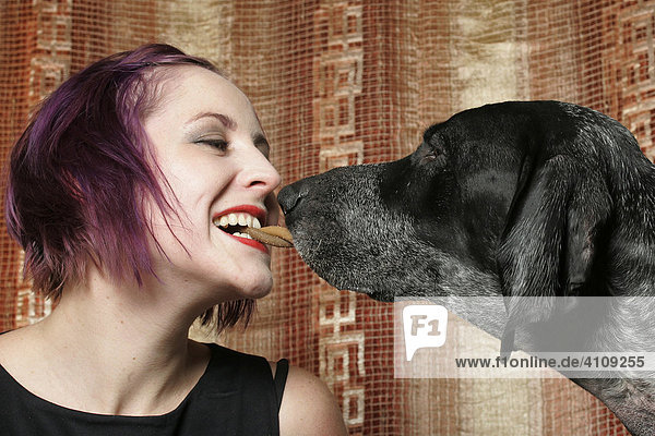 Eine junge Frau und ein Hund mit Hundeknochen