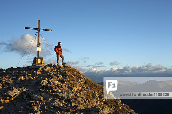Wanderer vor dem Gipfelkreuz des Großen Königstuhls  Nockberge  Kärnten  Österreich