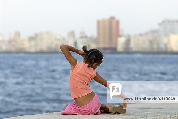 Girl sitting on the Malecón pier in Havana  Cuba  Caribbean  Americas