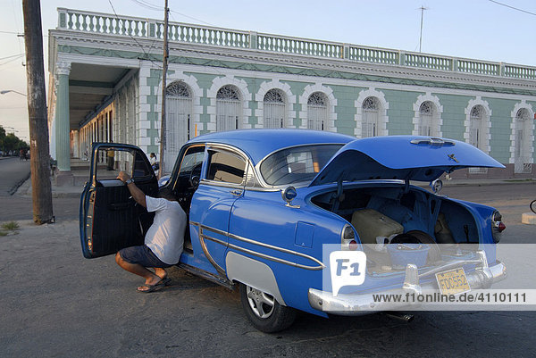 Oldtimer bei Reparatur mit offenem Kofferraum vor kolonialer Fassade  Cienfuegos  Kuba