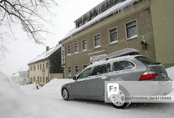 Auto auf der verschneiten Hauptstraße in Oberwiesenthal  Erzgebirge  Sachsen  Deutschland