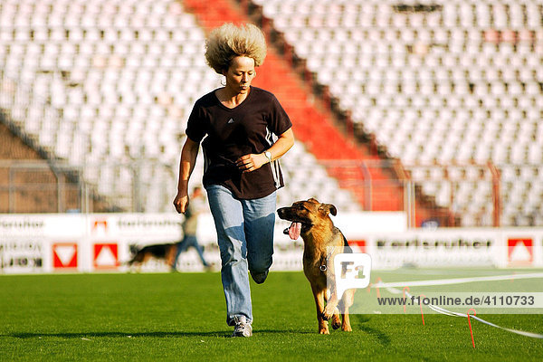 Junge frau rennt mit ihrem Deutschen Schäferhund in trauter Zweisamkeit