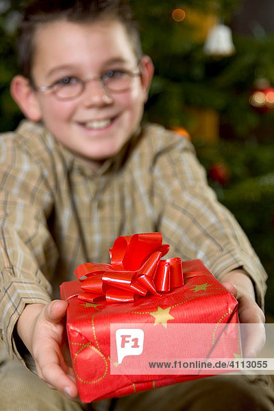 Junge überreicht freudig ein Geschenk