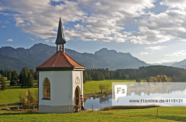 Kapelle an einem kleinen See im Herbst  Besucher an der Kapelle  Buching  Allgäu  Ostallgäu  Bayern  Deutschland  BRD  Europa