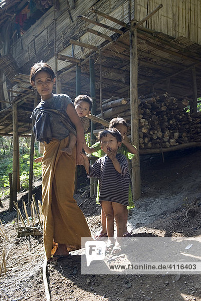 Junge Frau mit Kindern vor einem traditionellen Stelzenhaus  IDP-Camp Oh Win Hta  Flüchtlingslager an der Grenze zu Thailand nahe Mae Sam Raep  Burma